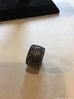 Close-up photo of wide band ring fully covered with marcasite stones showcasing its texture and sparkle.