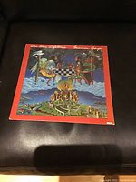 Front cover of Marvin Gaye's 1981 'In Our Lifetime' vinyl LP album showing colorful surreal art and red border with title and artist name.