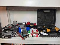 Overview of lot on white shelf including all pneumatic tools, fasteners and socket set