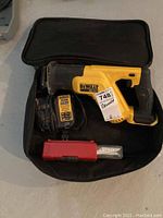 DeWalt 20V Max reciprocating saw with battery charger and red blade case in black carrying case.