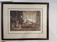 Framed and matted print titled 'Christmas Morning' by Trish Romance showing a detailed Christmas family scene in a library/living room setting with a fire burning in the fireplace.