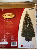 Product box showing brand, size, and product image of a 4 ft pre-lit pine Christmas tree.