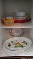Photo of multiple serving dishes showing Royal Worcester Evesham 'M' dishes, Pyrex mixing bowls, Fire King casseroles and Corning platter visually confirming lot's contents.