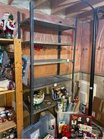 Metal utility shelf in basement setting with visible wear and contents removed.