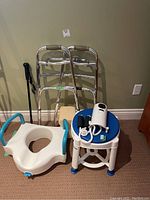 Photo showing whole mobility and bath aids set including walker, toilet seat riser, bath stool, walking stick, and sock aid
