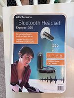 Front and back view of the Plantronics Explorer 395 Bluetooth headset packaging showing headset, car charger, and feature details.