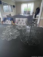 Three cupcake stands on a black table: two silver spiral design stands and one black tiered basket design stand.