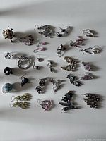 Overview of all earrings and rings in the lot, displaying the variety of dangle earrings with different colored beads and metal rings.