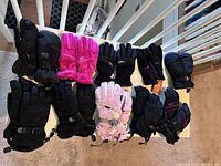 Lot of kids winter gloves and mittens shown on a white railing with some front and side views to display design and features