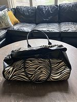 Top view of zebra print rolling travel bag showing handles and exterior details