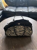 Front view of zebra print travel bag showing handle straps and shape