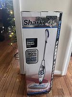Front of the Shark Sonic Steam Pocket Mop box showing product image, features like 30% faster cleaning and 10,000 scrubs per minute.