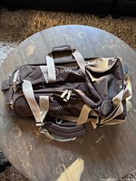 Top view of the brown Dynastar ski/snowboard rolling bag showing handles, zippers, and brand logo