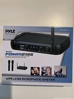 Boxed Pyle POWM2135 wireless microphone system with image of receiver and two microphones on packaging.