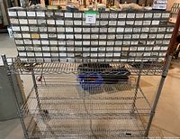 Wide view showing stacked bins filled with various labeled fasteners and the metal wire rack below.