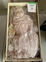 Numbered Victoria Ashlea collectible doll in original box with damaged box condition. Doll visible in clear packaging with bubble wrapped hands and feet.
