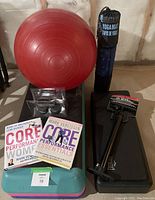 Red small yoga ball, yoga mat in carrying sleeve, two fitness books, Weider ankle weights, part of aerobic stepper and bicycle pump