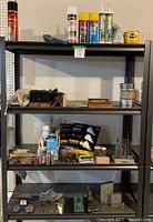 Full view of top to third shelves showing anvil, drill indexes, tape measures, electrical items, brushes, honing bar and assorted small tools.