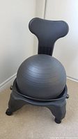 Front view of the black exercise ball chair showing ball, back support and wheeled base.