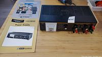 BK Precision 1650 power supply with manuals beside it. Manual covers show 'BK Precision 1650' and an additional power supply manual with a photo of the supply.