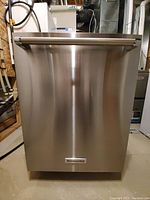 Front view of closed dishwasher door showing stainless steel exterior and horizontal tubular handle