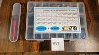 Top view of plastic case with O-rings and separate small box with red metal removal tools, label on case lists sizes and quantities of 1200 pieces in 24 sizes.