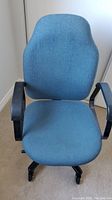 Front view of heavy duty office chair with blue fabric upholstery and black armrests.