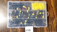Plastic case with multiple compartments containing black male and female waterproof connectors and numerous yellow rubber seals.
