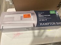 Photo showing the boxed Hampton Bay Havelock LED Vanity Fixture with model number and chrome finish details.