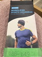 Box front showing product name 'LC-dolida Wireless Sports Headwear', an image of a male model wearing the black headwear and t-shirt.