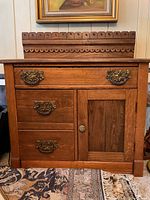 Full front view of the oak washstand showing carved gallery and drawer layout