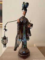 Front view of cloisonné lady figurine showing enamel detail and lantern