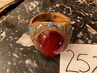 Front view showing large red agate cabochon and surrounding gold-tone filigree