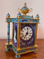 Three-quarter view showing overall case shape, urn finial and cloisonné panels