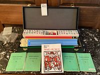 Open carrying case showing interior with racks, tile boxes, scoring accessories, and booklets