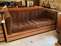 Front and side view showing tufted brown corduroy cushions, oak frame and tweed inset panel