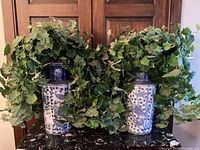 Both vases side by side with faux ivy plants visible in each