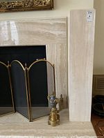Pair of travertine pedestals flanking a fireplace, front view