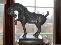 Side profile view showing the rearing horse form and base