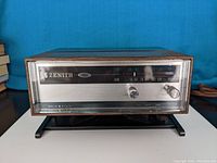 Front view of the Zenith AM/FM radio with the tuning dial showing AM frequencies and knobs visible on the right side.