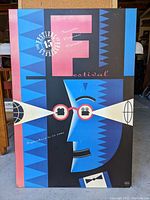 Full view of the 1990 TIFF 15 Year Anniversary poster featuring the blue geometric face, festival text, and color blocks