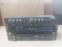 Front view of the four stacked rack mount units: Symetrix 525 top, Rane AC 23, Pyramid stereo preamplifier, and Teac AN-80 noise reduction at bottom