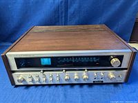 Front and angled view of Planar XR 4120 receiver showing wood casing, metal front panel, control knobs, and tuner display.