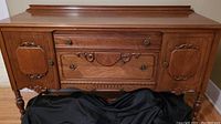 Front view of Gibbard wood buffet sideboard with two drawers and two cupboards, showing decorative carved details and brass hardware.