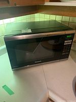 Front view of Panasonic microwave on countertop showing overall condition and control panel.
