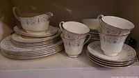 Sets of stacked Minton Beaumaris dishes including cups, saucers, plates, and gravy boat with underplate arranged on a shelf