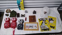 Overview photo showing all items: Kit Kat clocks, signed Pirates helmet, yearbook, hand carved trivet, military items, ashtray, pewter figure, bicycle bell, opera glasses