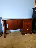 Front side view showing four drawers and leg space opening on left side, wood finish, minor scratches.