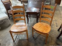 Pair of wooden ladder back dining chairs shown from front.
