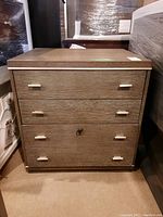 Front view of the wooden file cabinet showing the three drawers, silver handles, and lock on bottom drawer with key.